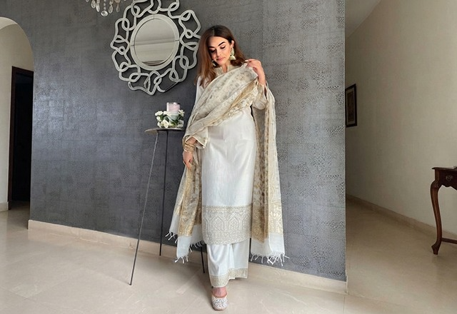Woman wearing an elegant white ethnic suit showcasing timeless Indian traditional wear.